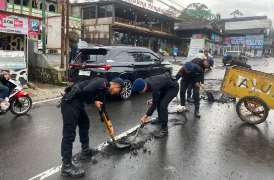 Brimob Polda Jabar Bersihkan Material Sisa Aspal Akibat Hujan Deras di Cikole Lembang